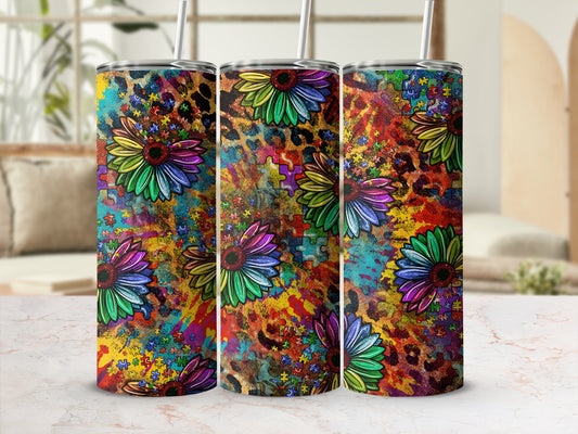 Three colorful tumblers with sunflower and puzzle piece designs.