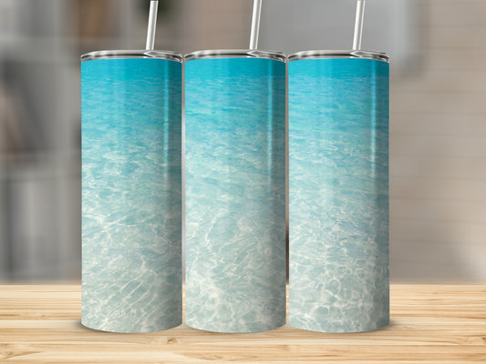 Three tumblers with a blue ocean water and sand design.