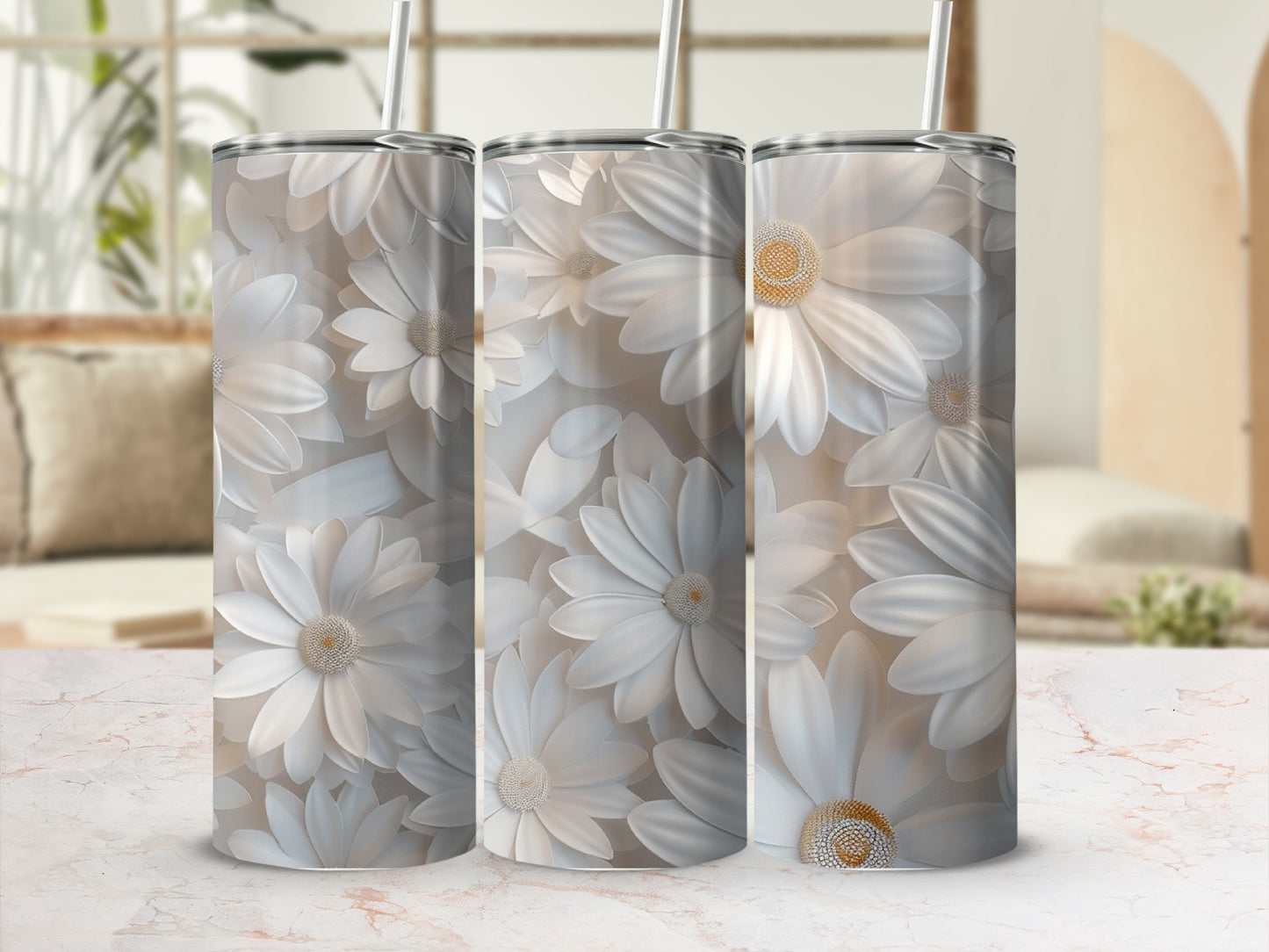 Three white daisy tumblers with straws on a marble surface.
