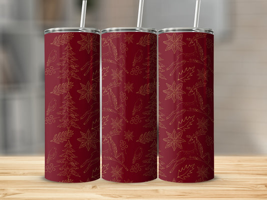 Red tumbler with gold Christmas pattern of deer, trees, and poinsettias.