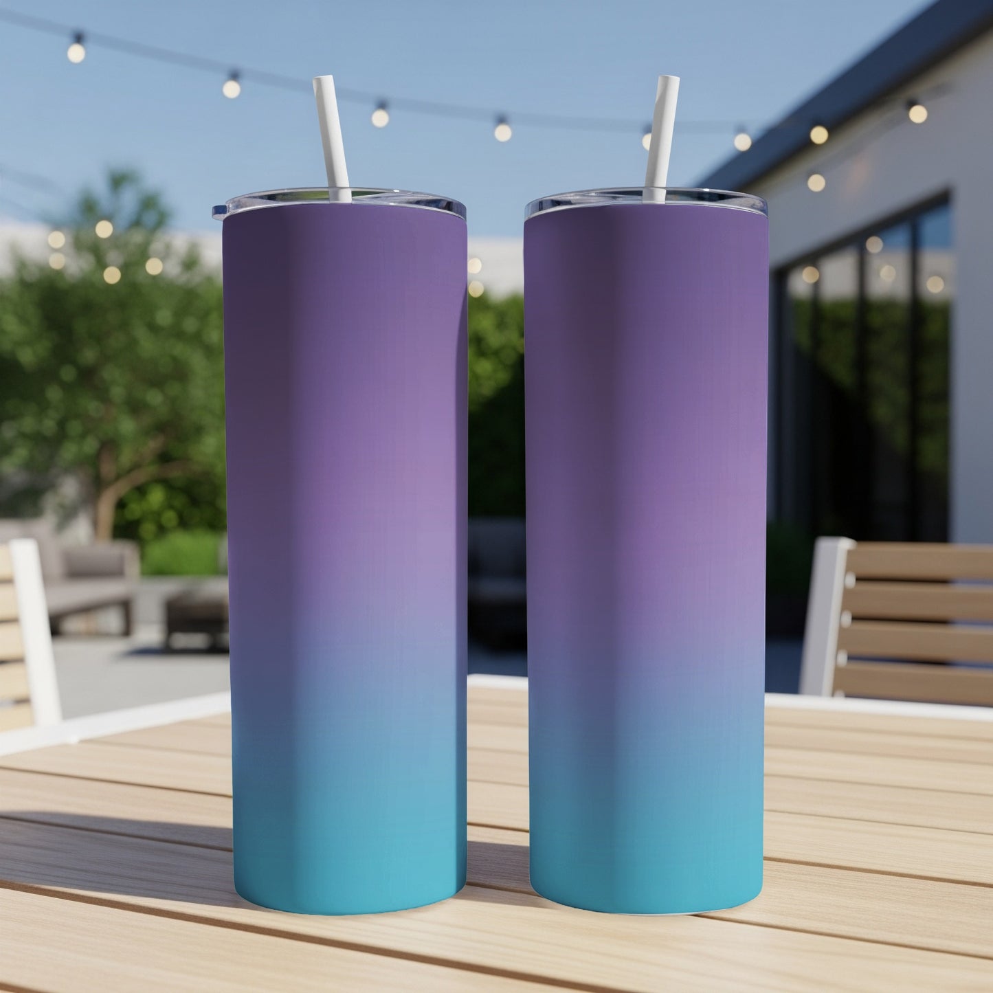 Two gradient tumblers, purple to teal, sit on a wooden table outdoors.
