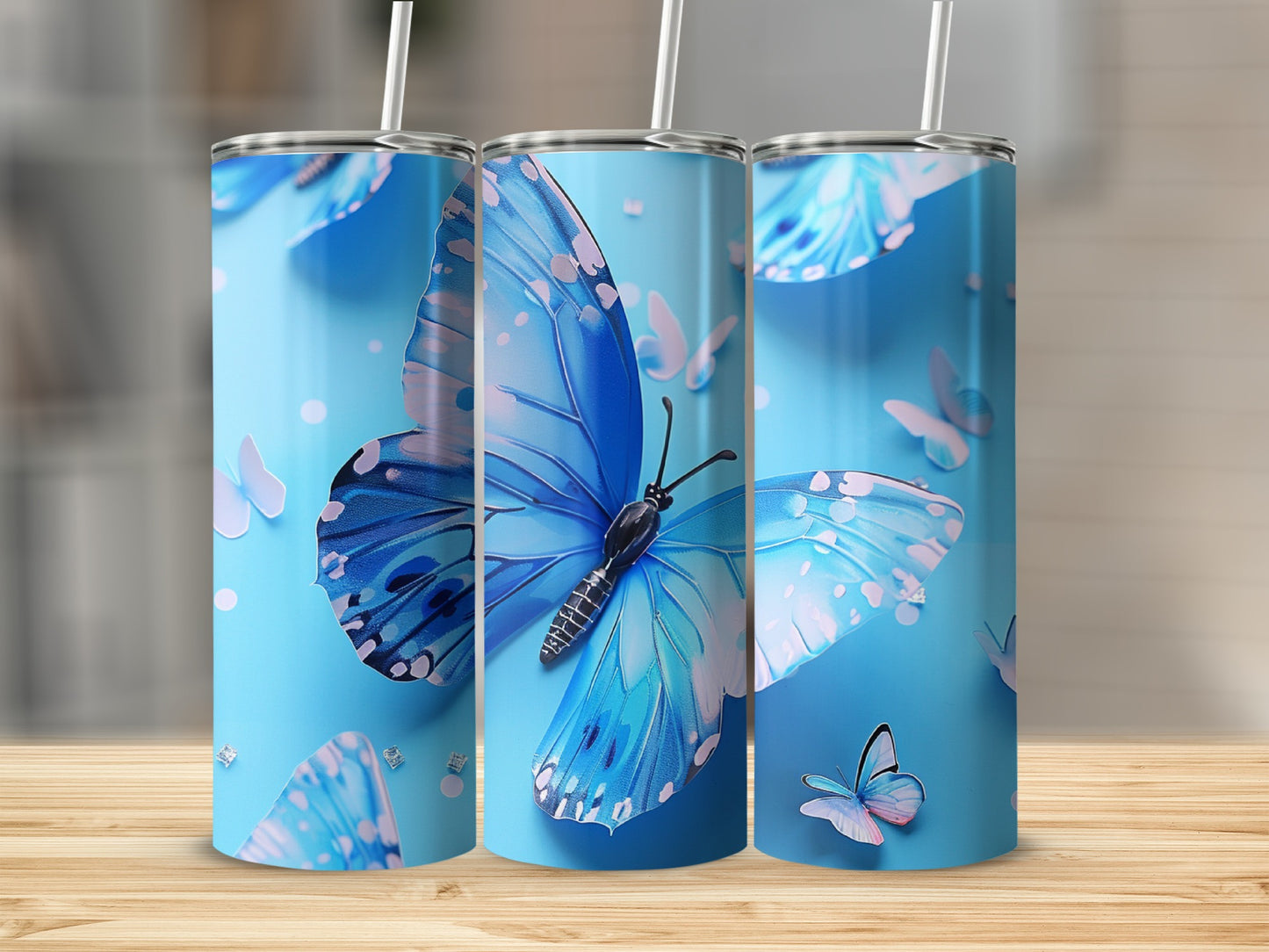 Three blue butterfly tumblers on a wooden surface.