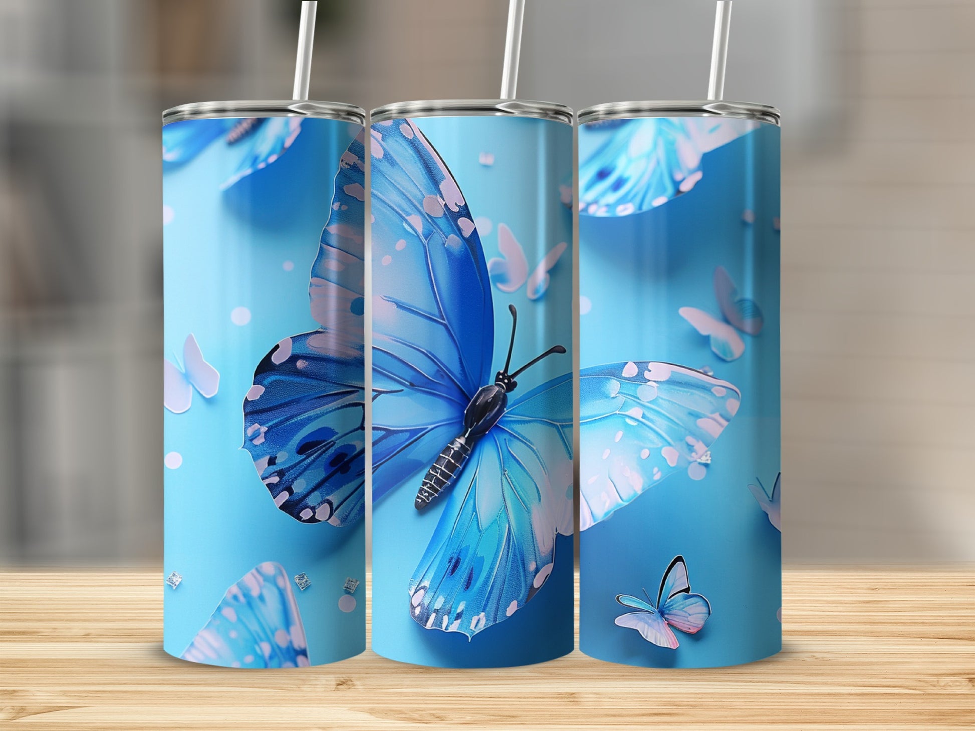 Three blue butterfly tumblers on a wooden surface.