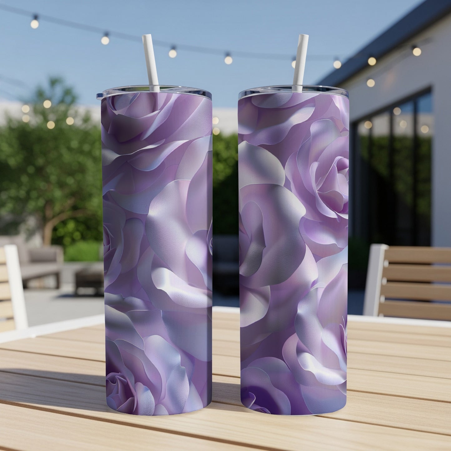 Two purple floral print tumblers with straws on a wooden table.