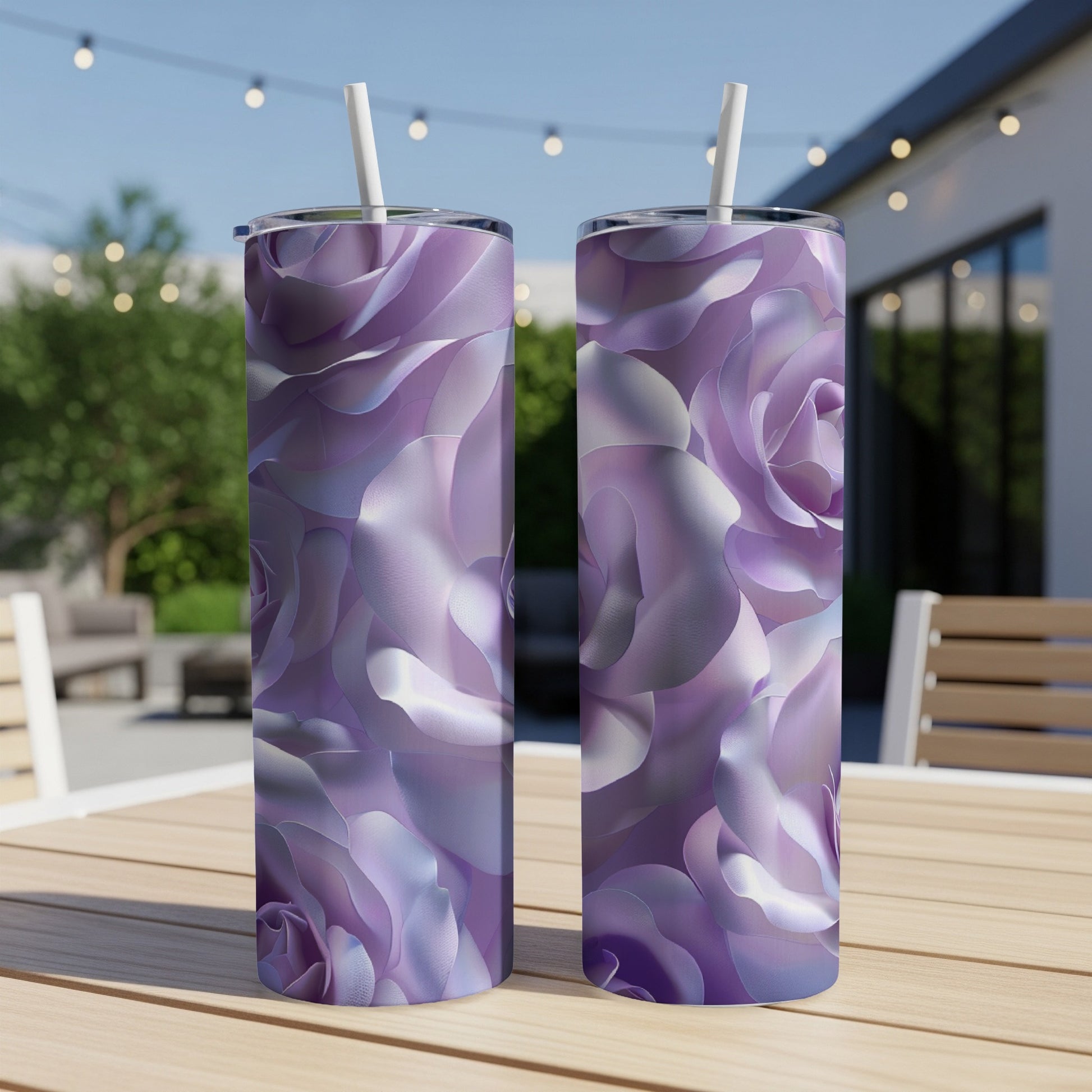 Two purple floral print tumblers with straws on a wooden table.