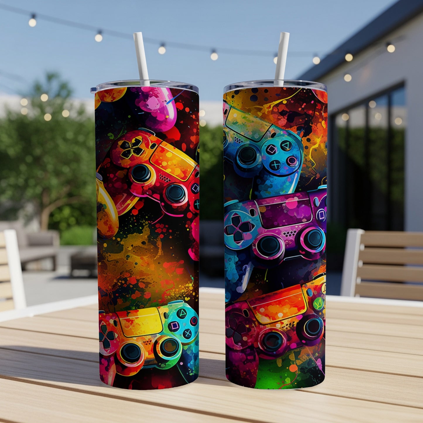 Two tumblers with colorful video game controller designs and abstract paint splatters.