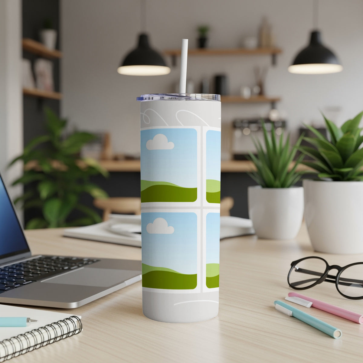 White tumbler with sky and rolling green hills pattern and a straw.