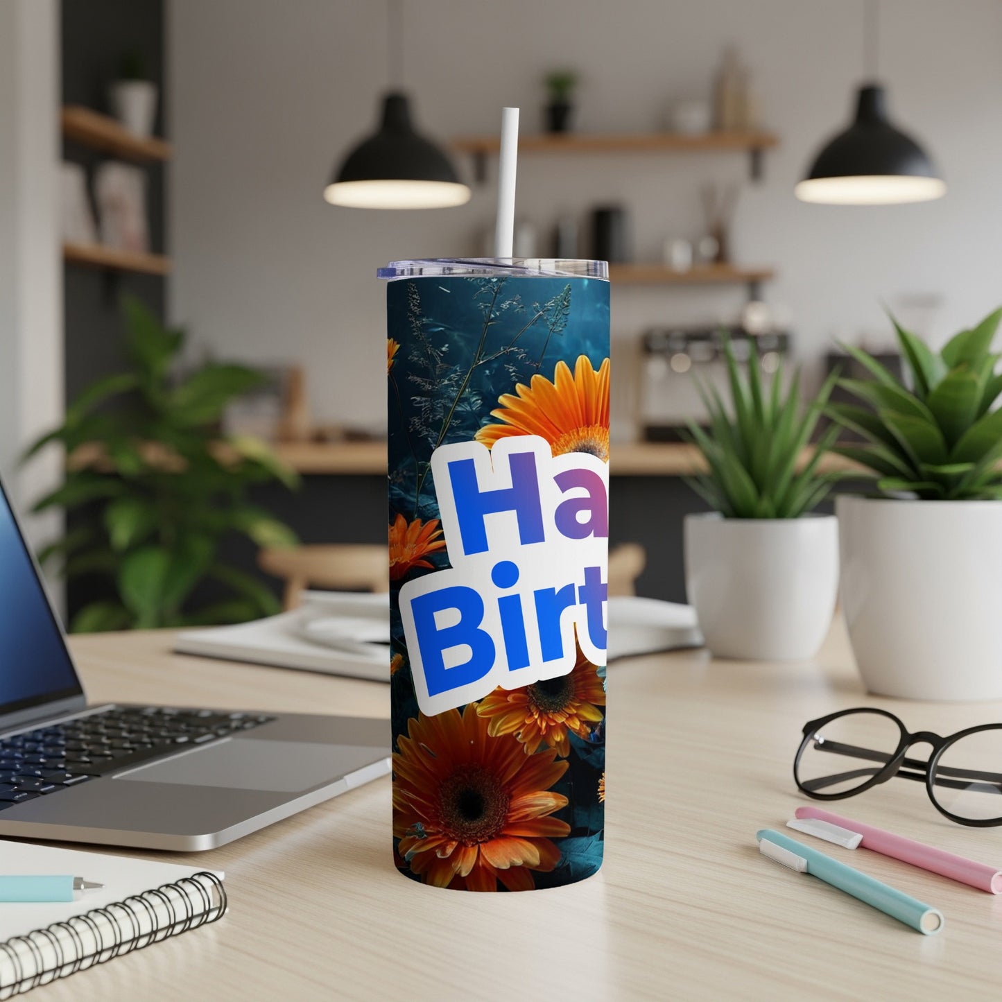 Tumbler with "Happy Birthday" text and floral design on a desk.