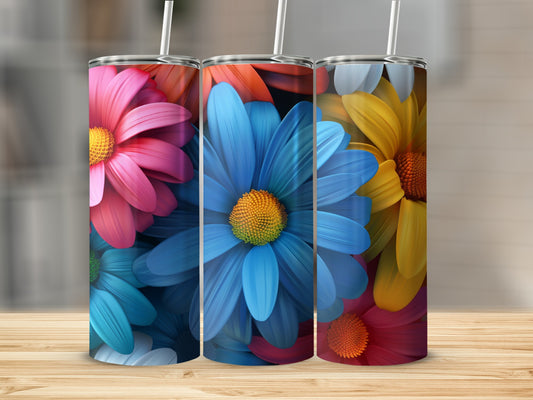 Three colorful flower tumblers with straws on a wooden surface.
