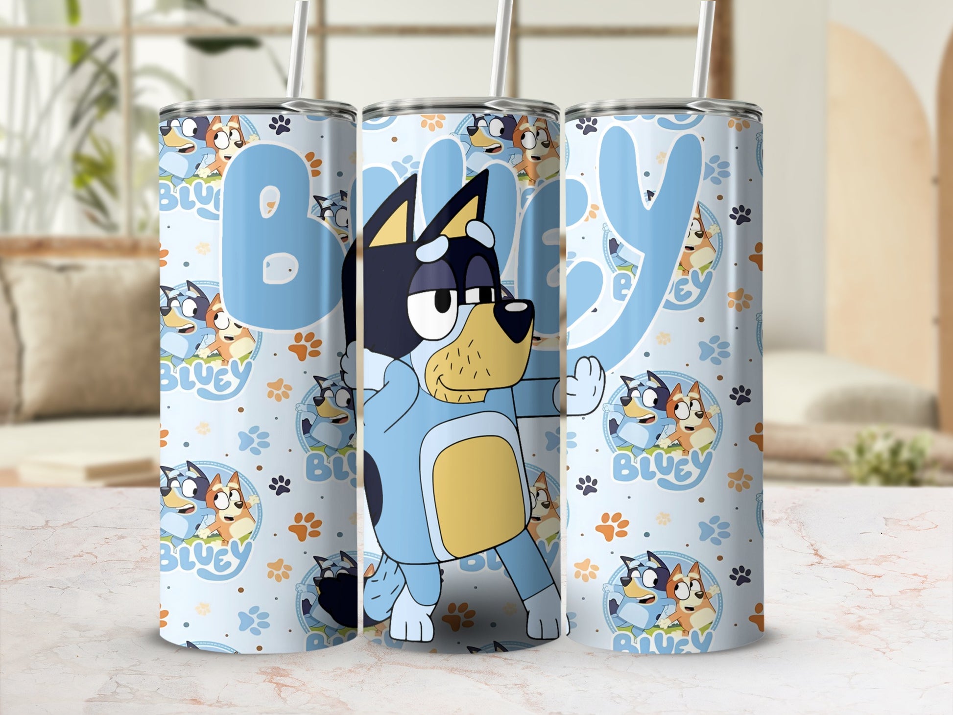 Bluey and Bingo characters on a light blue tumbler with cartoon paw prints.