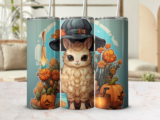 Tumbler with fluffy cat wearing witch hat, surrounded by pumpkins and flowers.