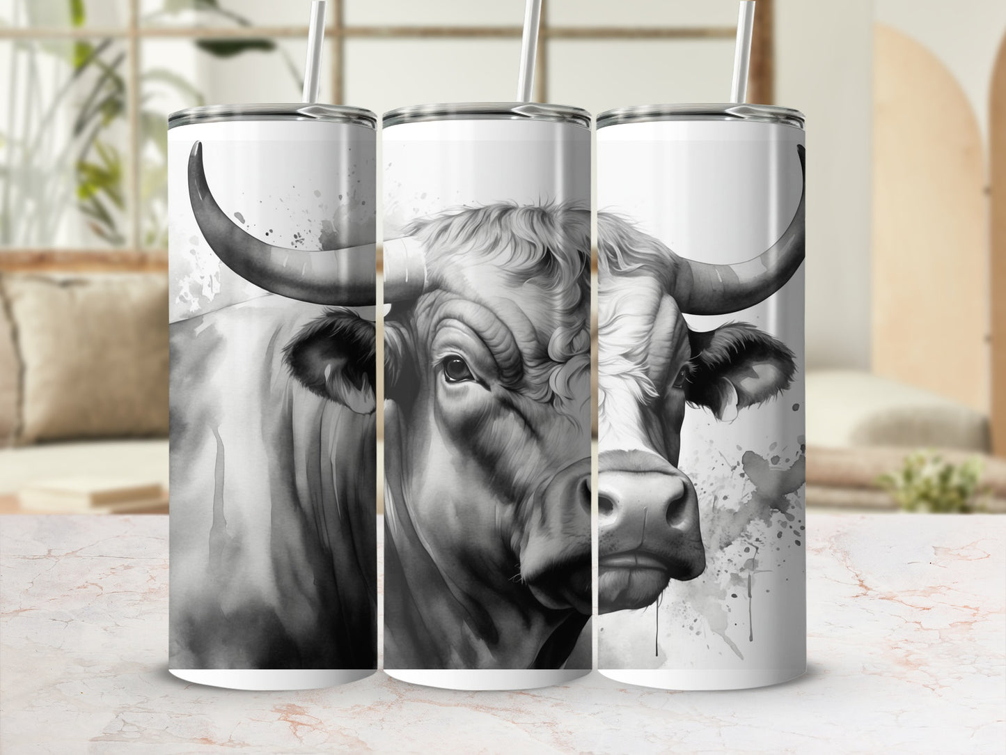 Black and white bull artwork on three tumblers with straws.