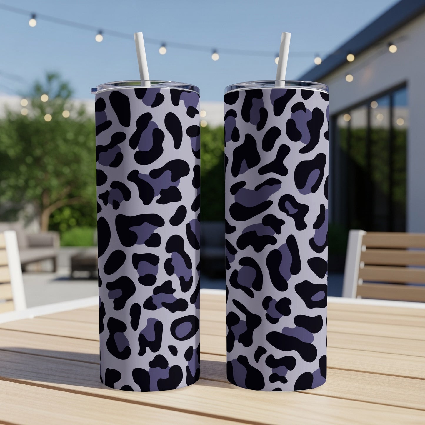 Two tumblers with a purple and black leopard print design sit on a table.