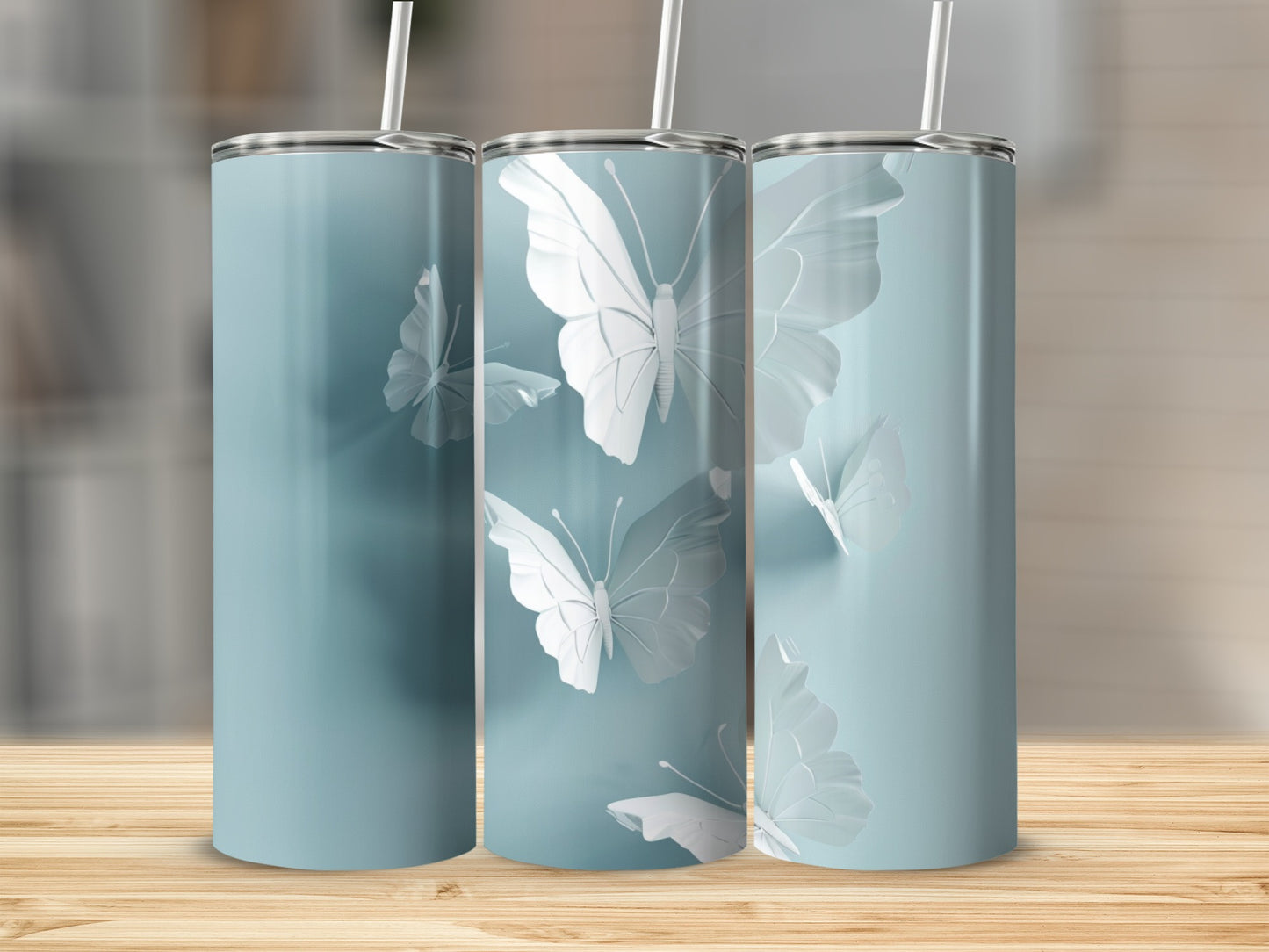 Three blue tumblers with raised white butterfly designs and straws.