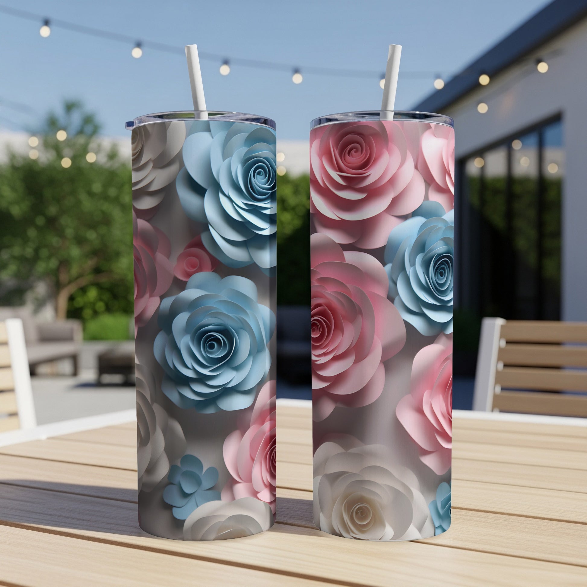 Two tumblers with floral designs in pink and blue sit on a wooden table.