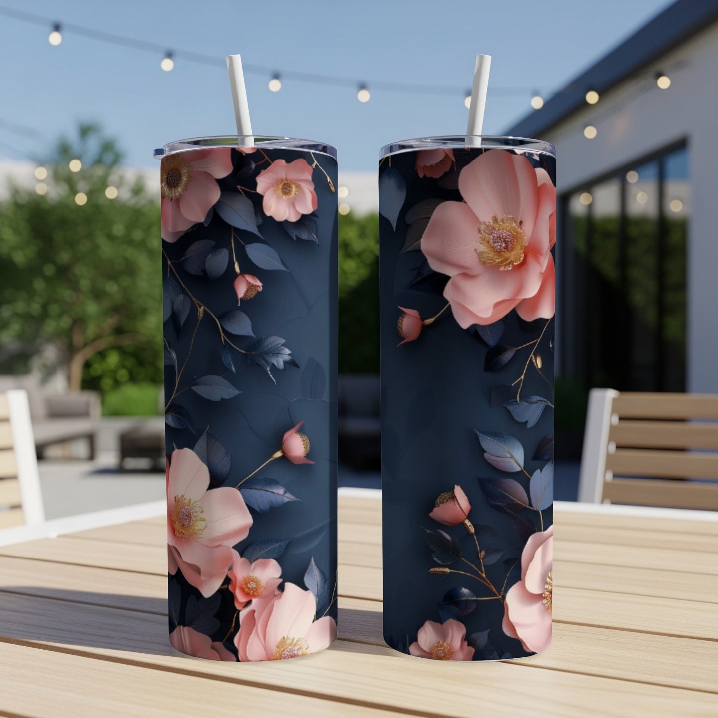 Two dark navy tumblers with a pink floral pattern sit on a table.