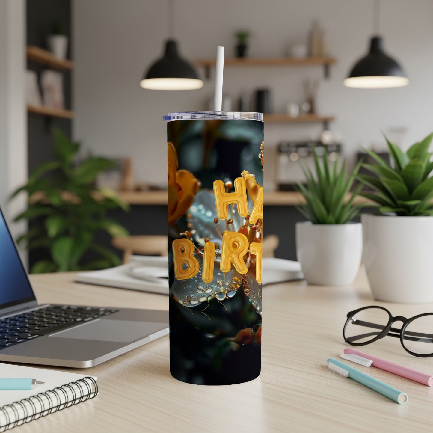 Gold "Happy Birthday" text on a tumbler with water droplets, on a desk.