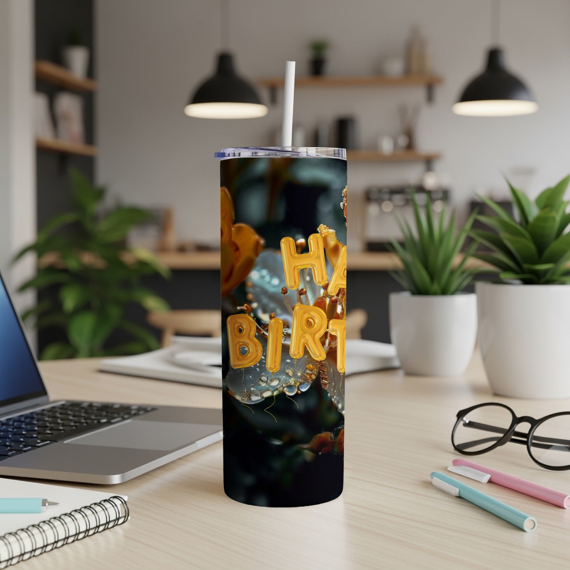 Gold "Happy Birthday" text on a tumbler with water droplets, on a desk.