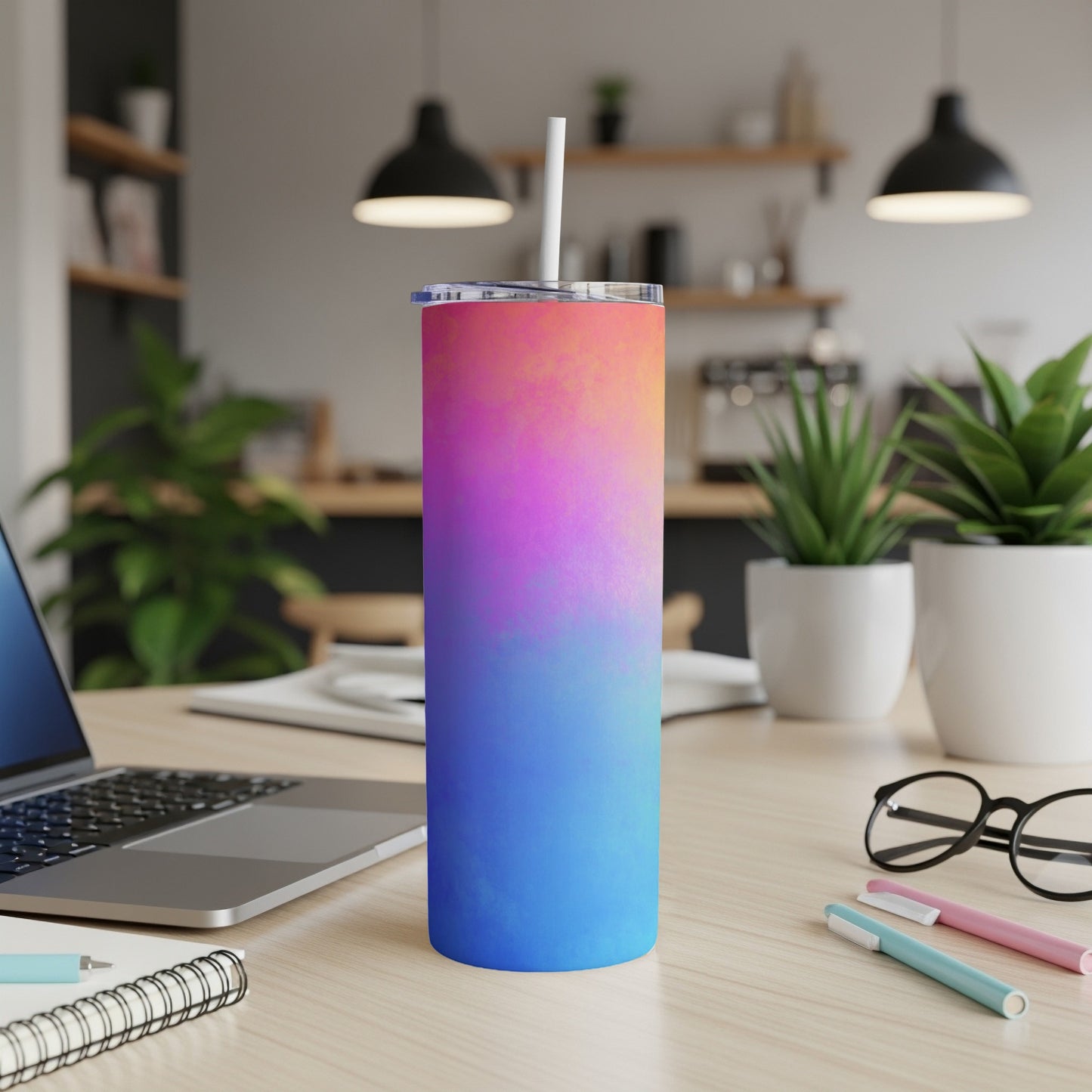 Gradient tumbler with a colorful ombre design sits on a desk.