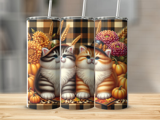 Two cute kittens with pumpkins and autumn flowers on a plaid background.