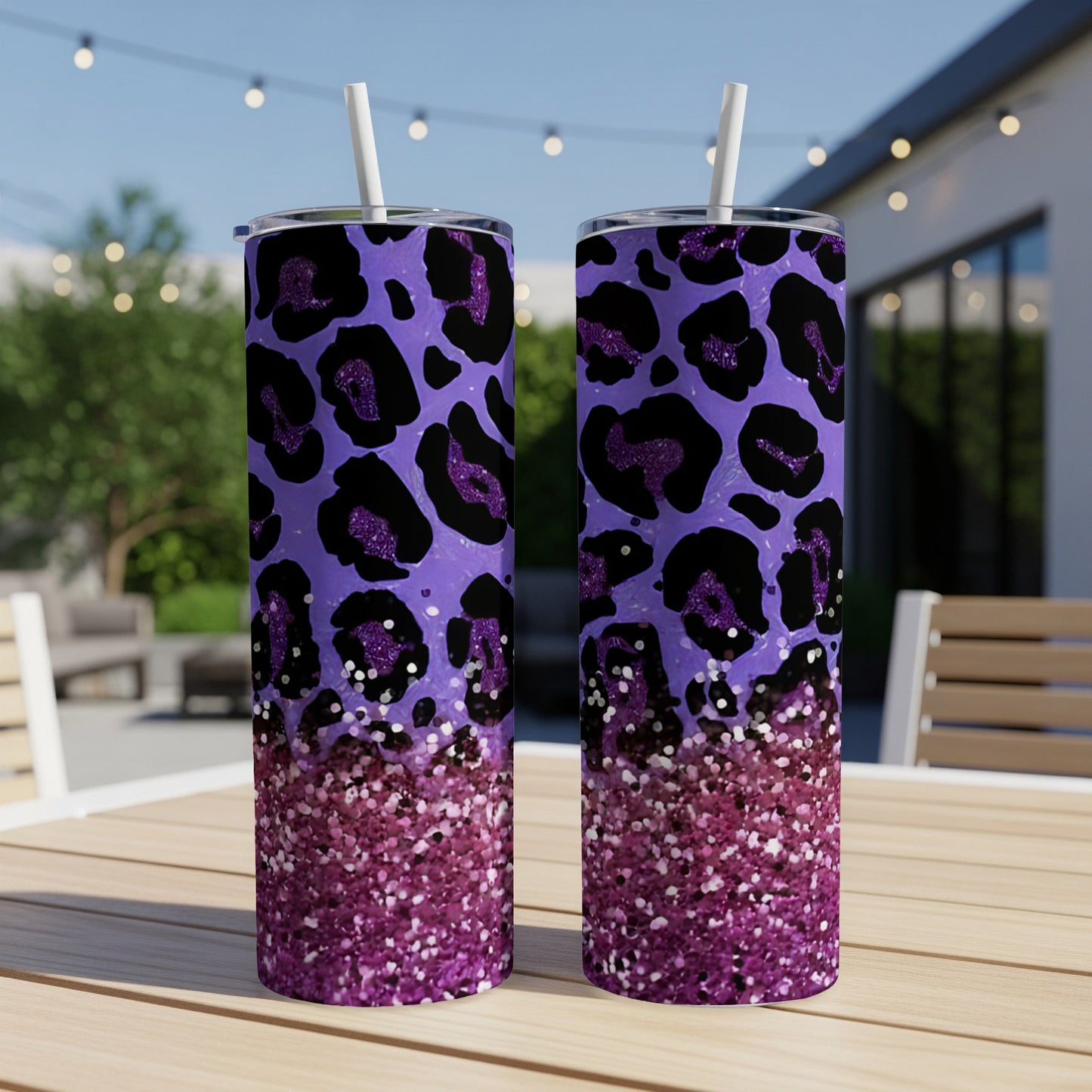 Two purple glitter leopard print tumblers with straws on a table.