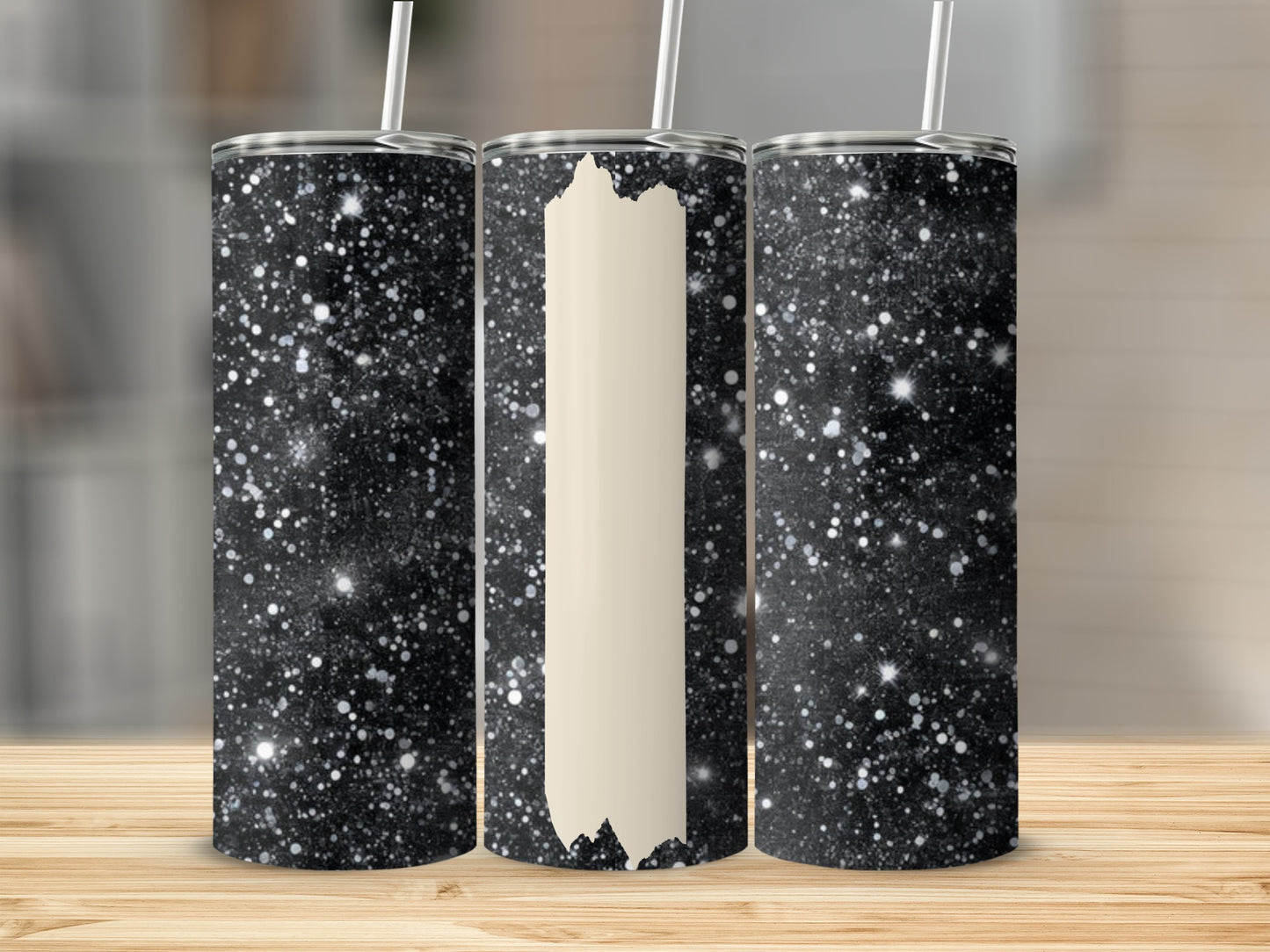 Three glitter-covered tumblers with white lids and straws, one blank.