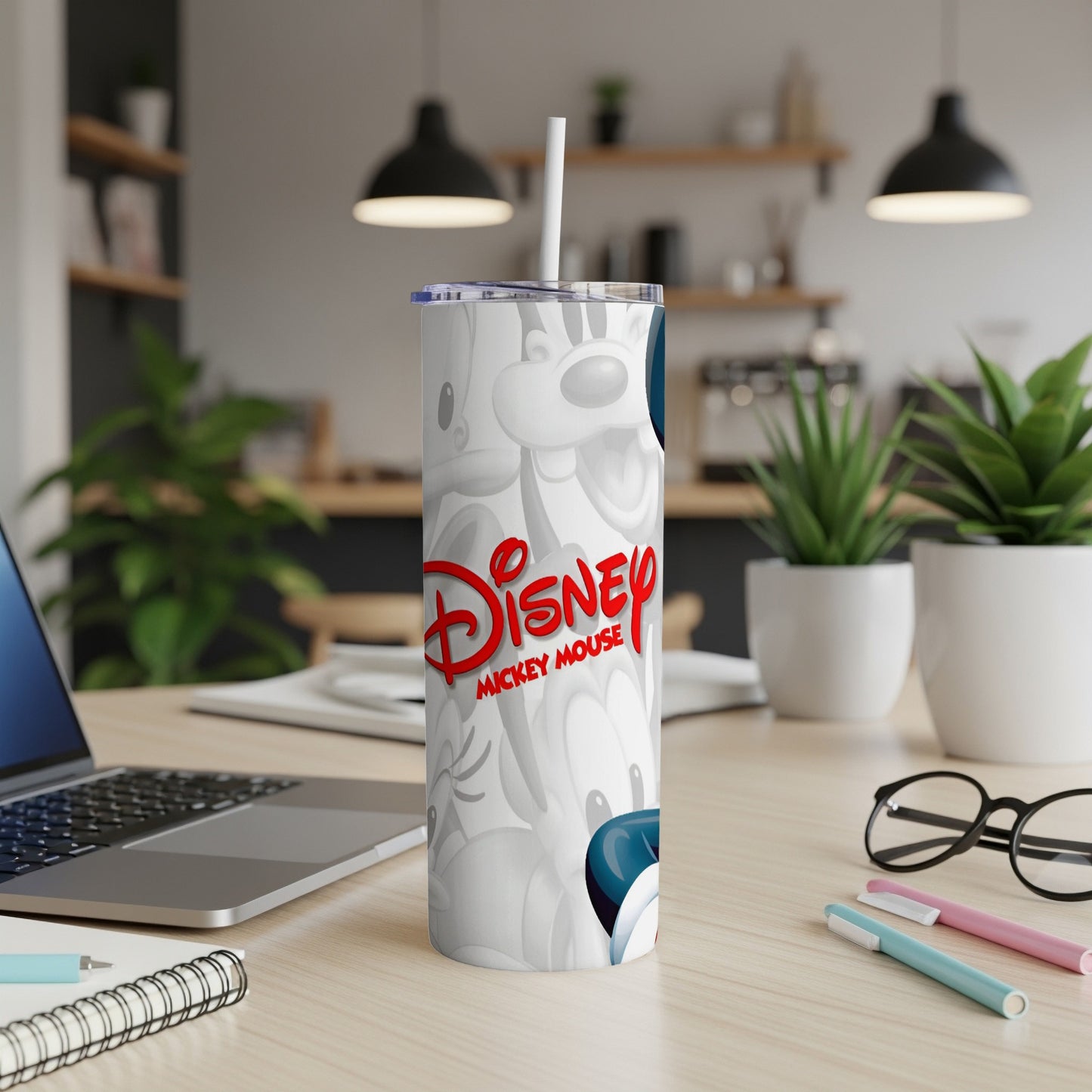 Disney Mickey Mouse tumbler with lid and straw on desk.