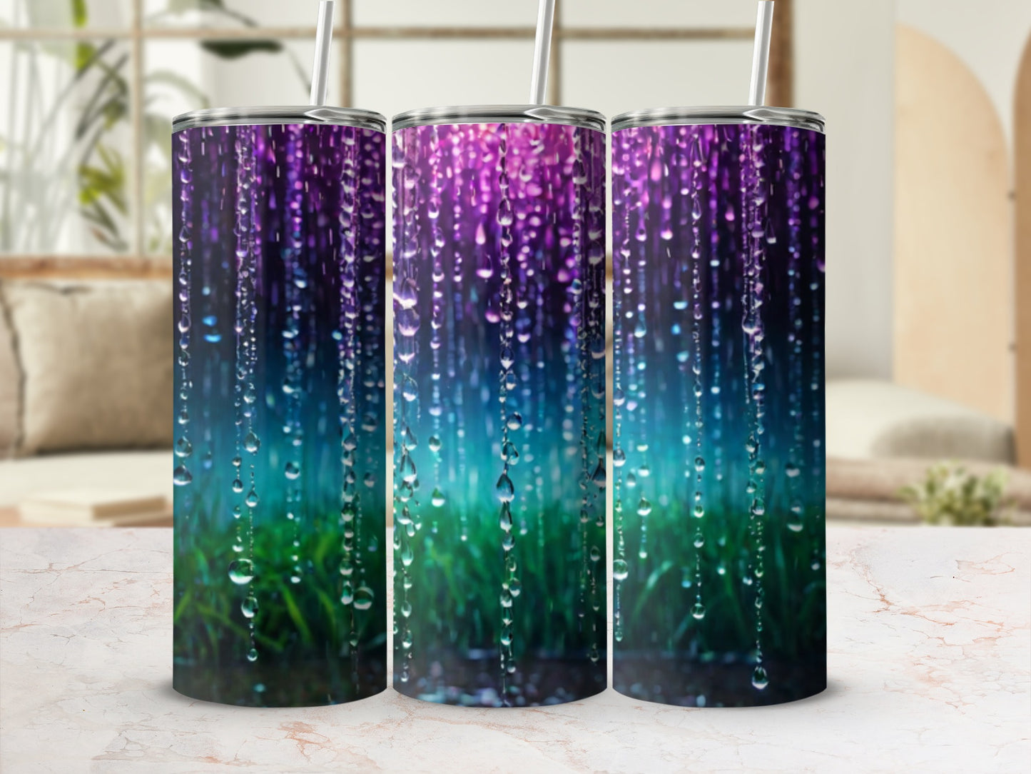 Three tumblers with a colorful, rain-like design on a marble surface.