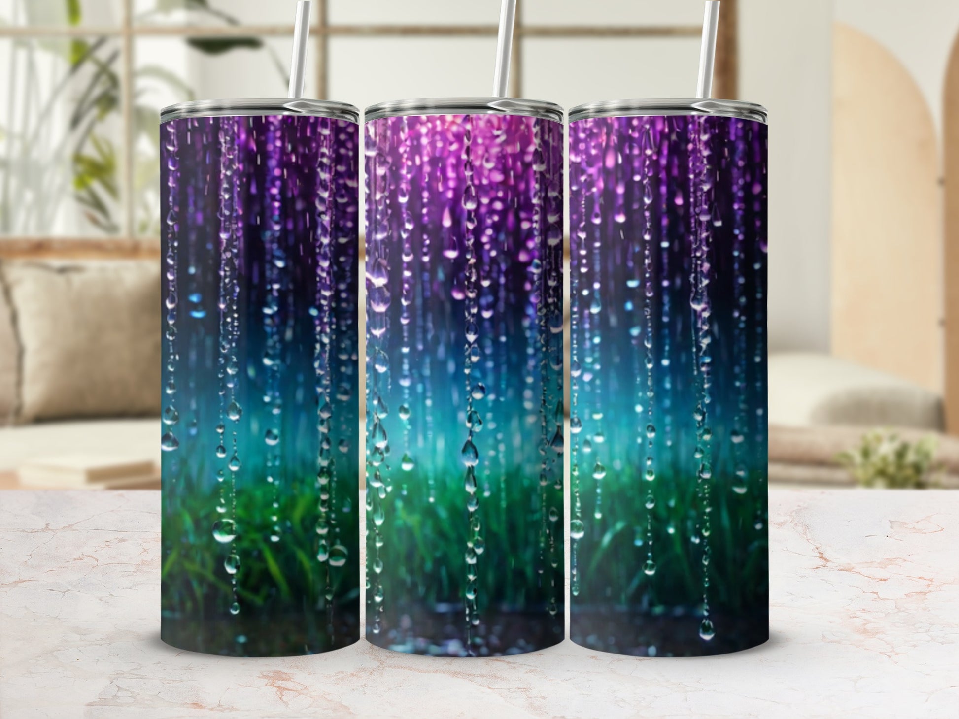 Three tumblers with a colorful, rain-like design on a marble surface.