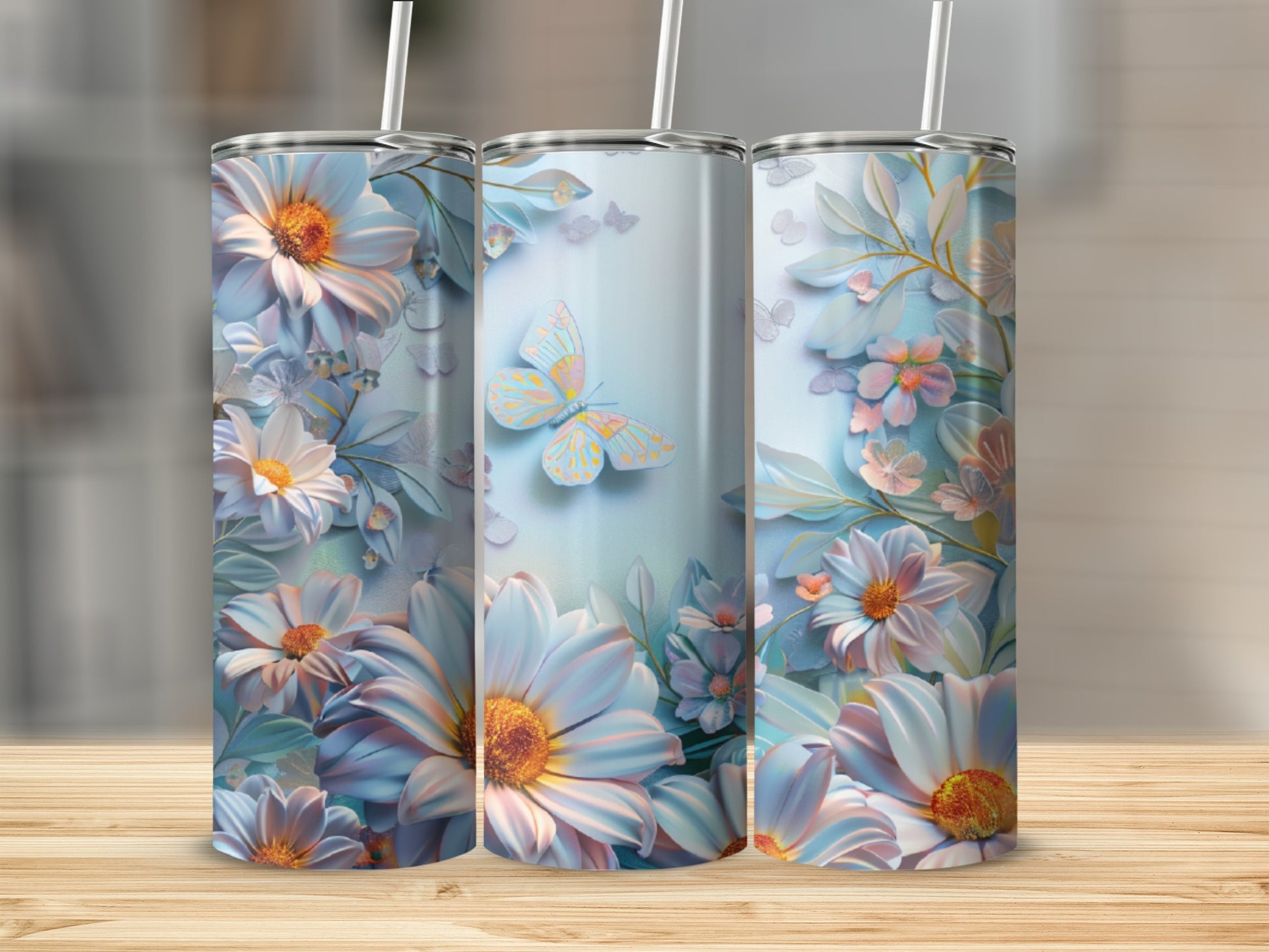 Three tumblers with floral and butterfly designs on a wooden surface.