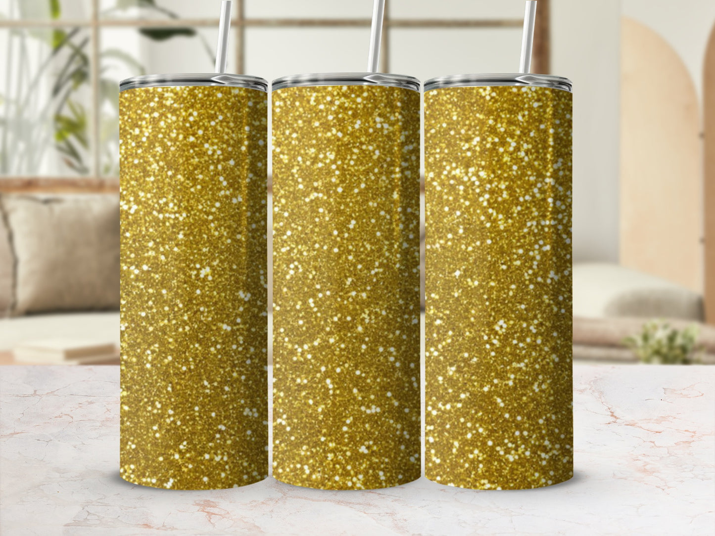 Three gold glitter tumblers with straws stand side-by-side.