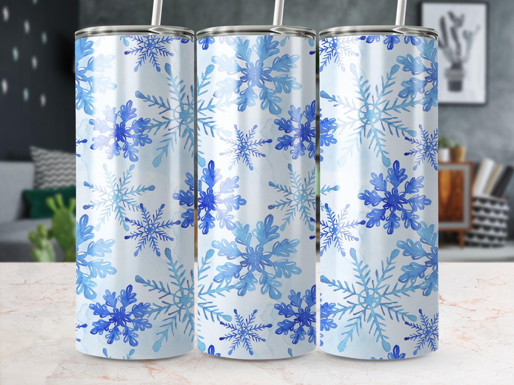 Three tumblers with blue watercolor snowflakes on white background.