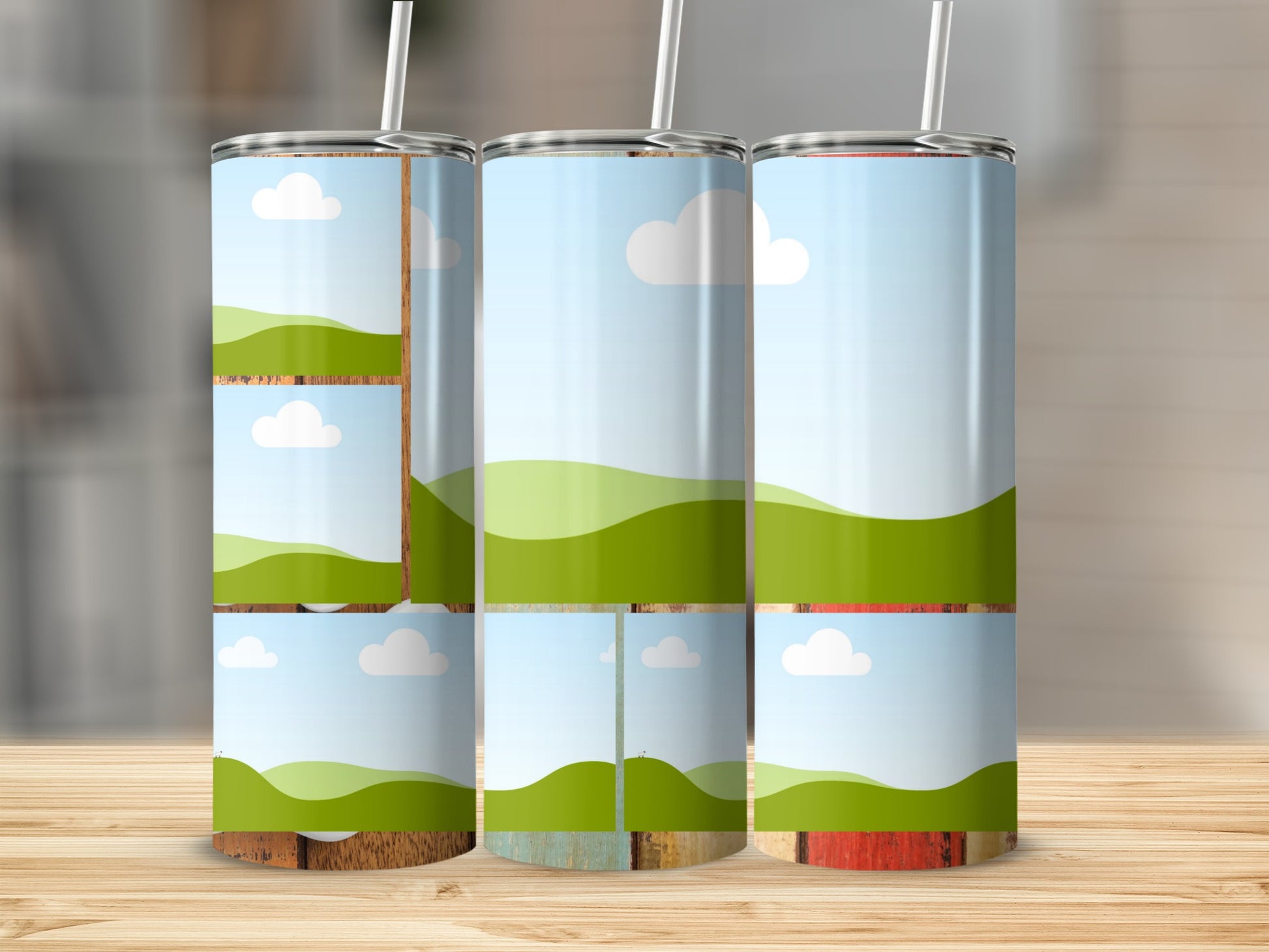 Three tumblers with a landscape design of green hills and blue skies with clouds.