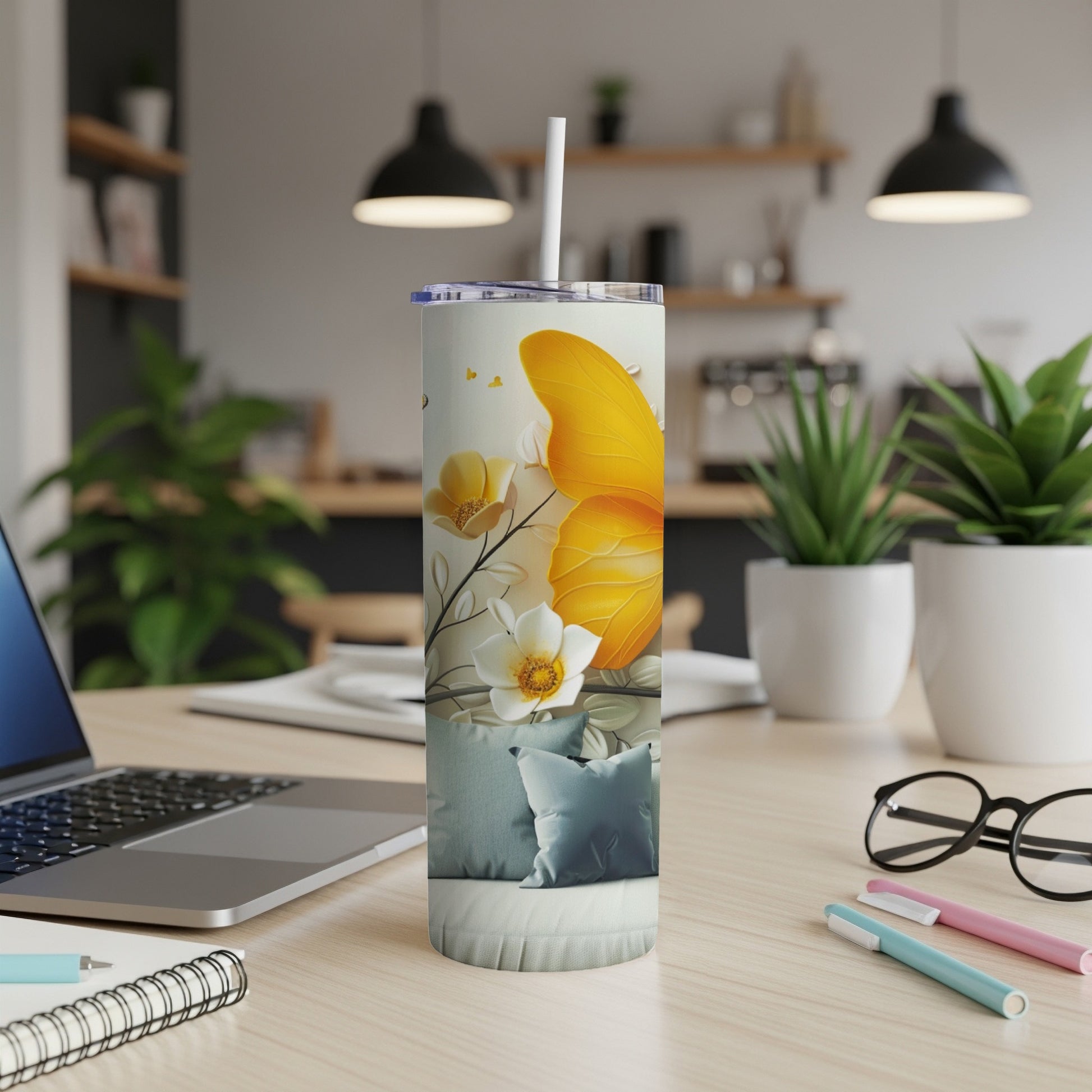 Yellow butterfly and floral design on a white tumbler with a straw.