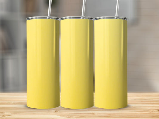 Three plain yellow tumblers with white straws on a wooden surface.