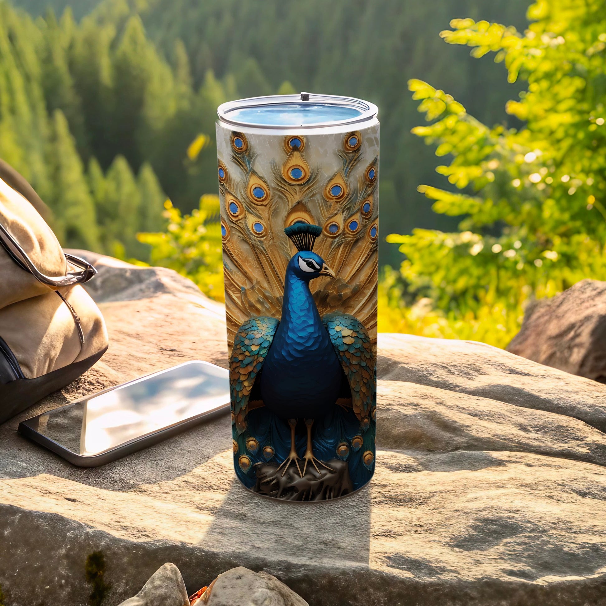 Tumbler featuring a vibrant peacock with detailed feathers, placed on a rock.