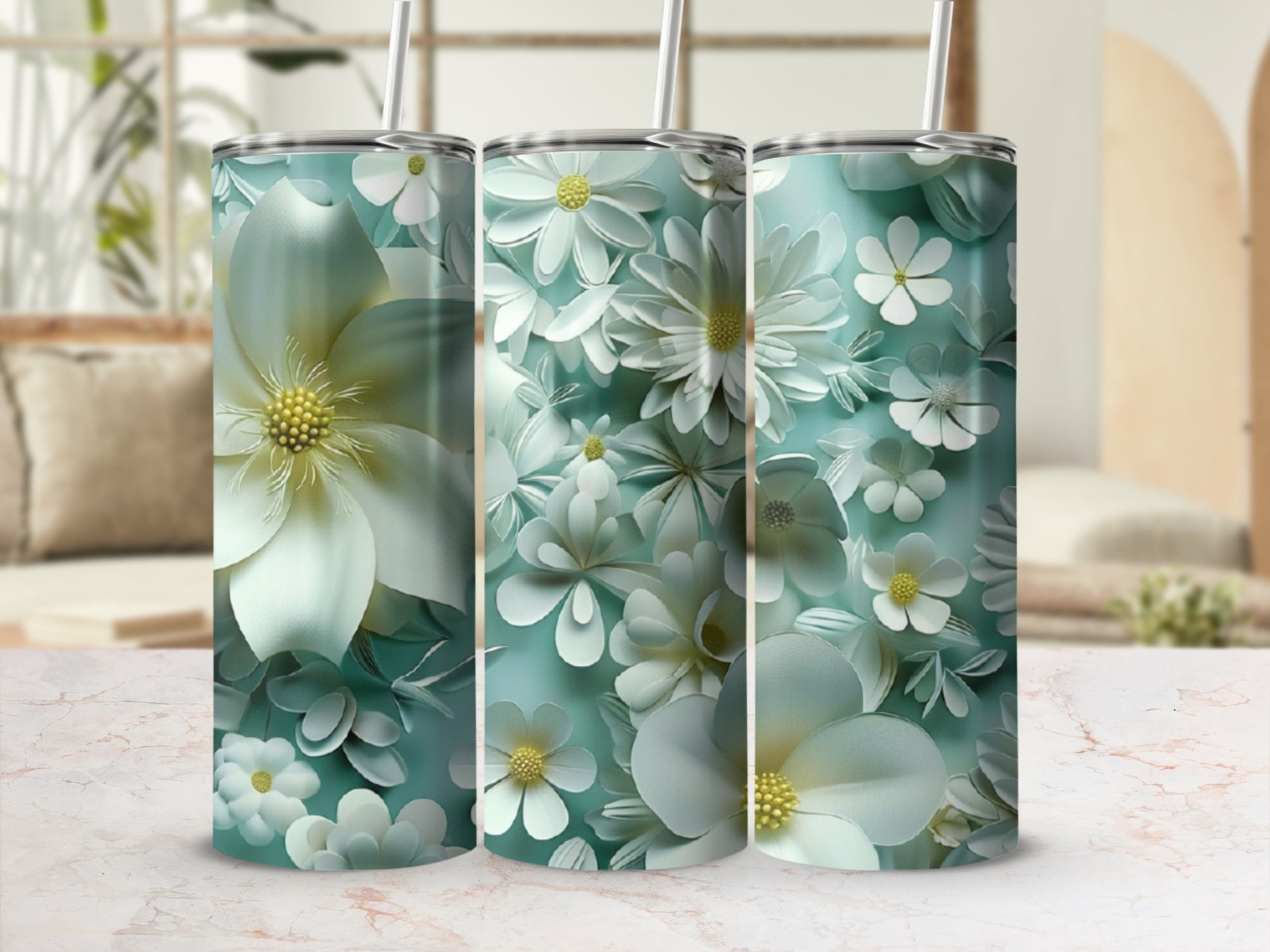 Three teal tumblers with white floral designs and yellow centers.