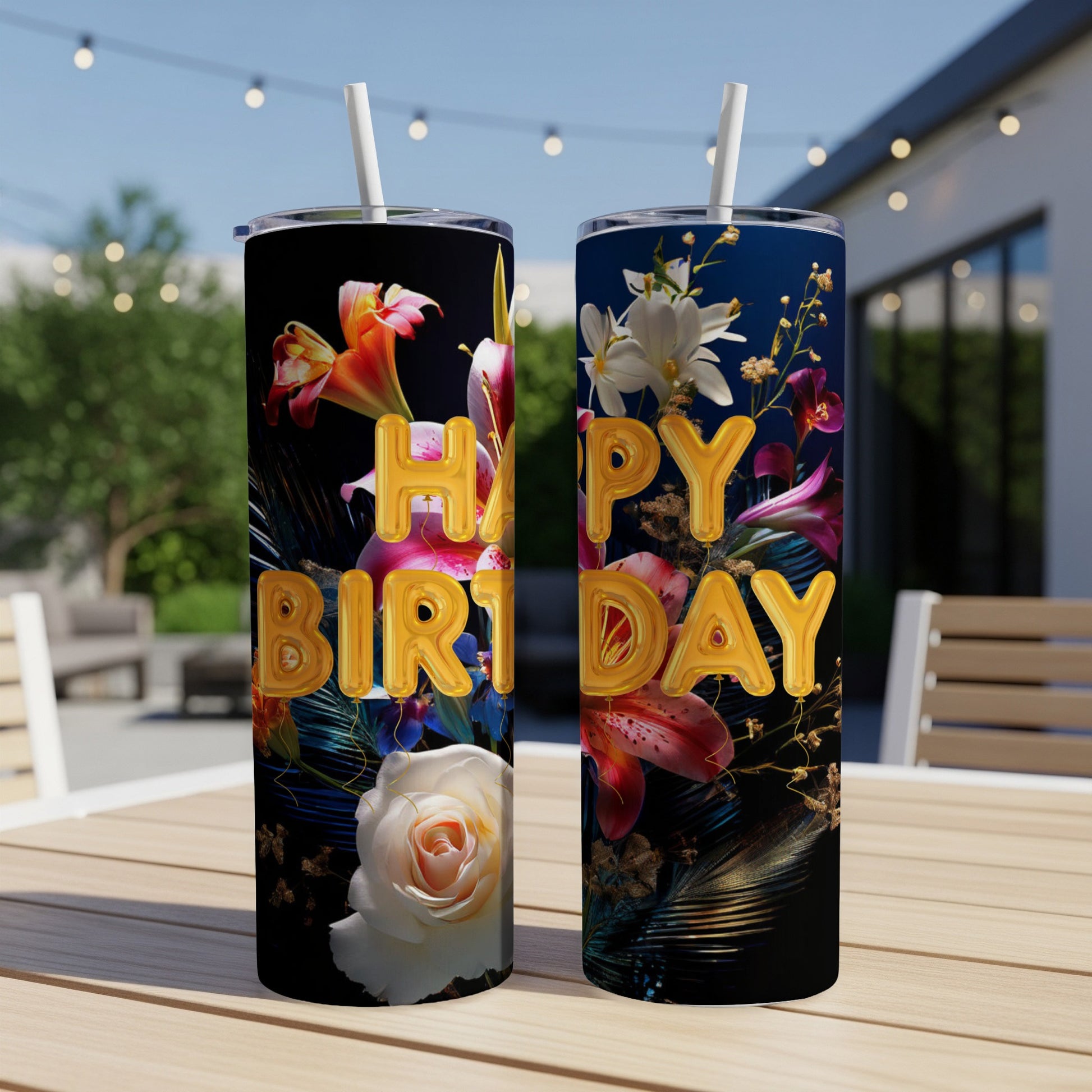 Floral Happy Birthday tumbler with straw on outdoor table.