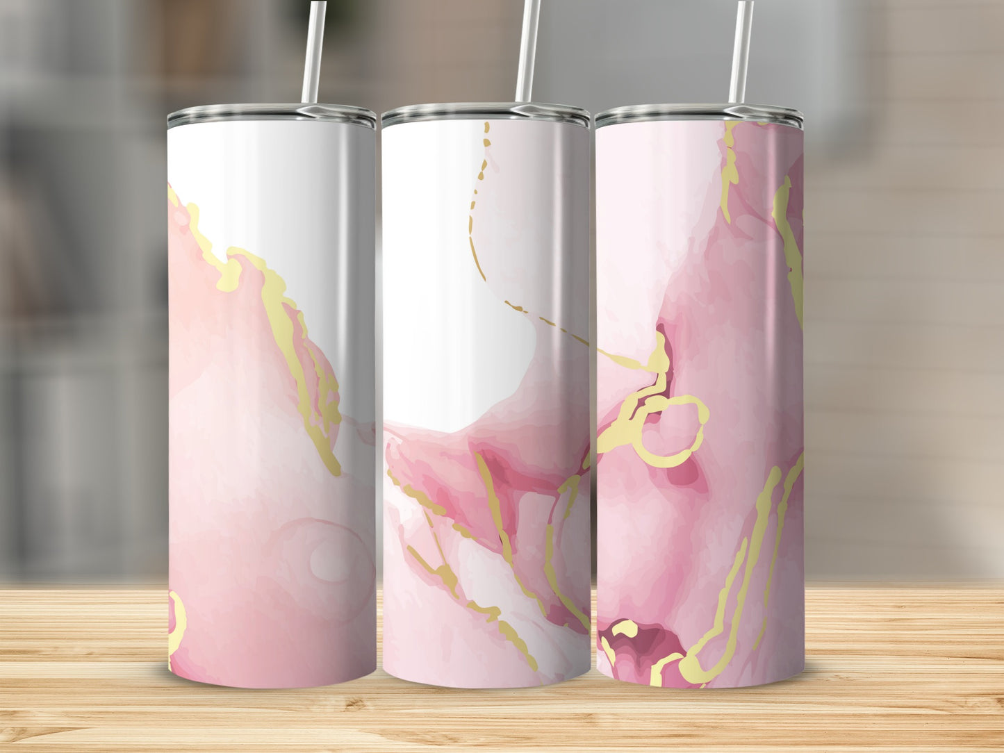 Three tumblers with pink and gold marbled design on a wooden surface.