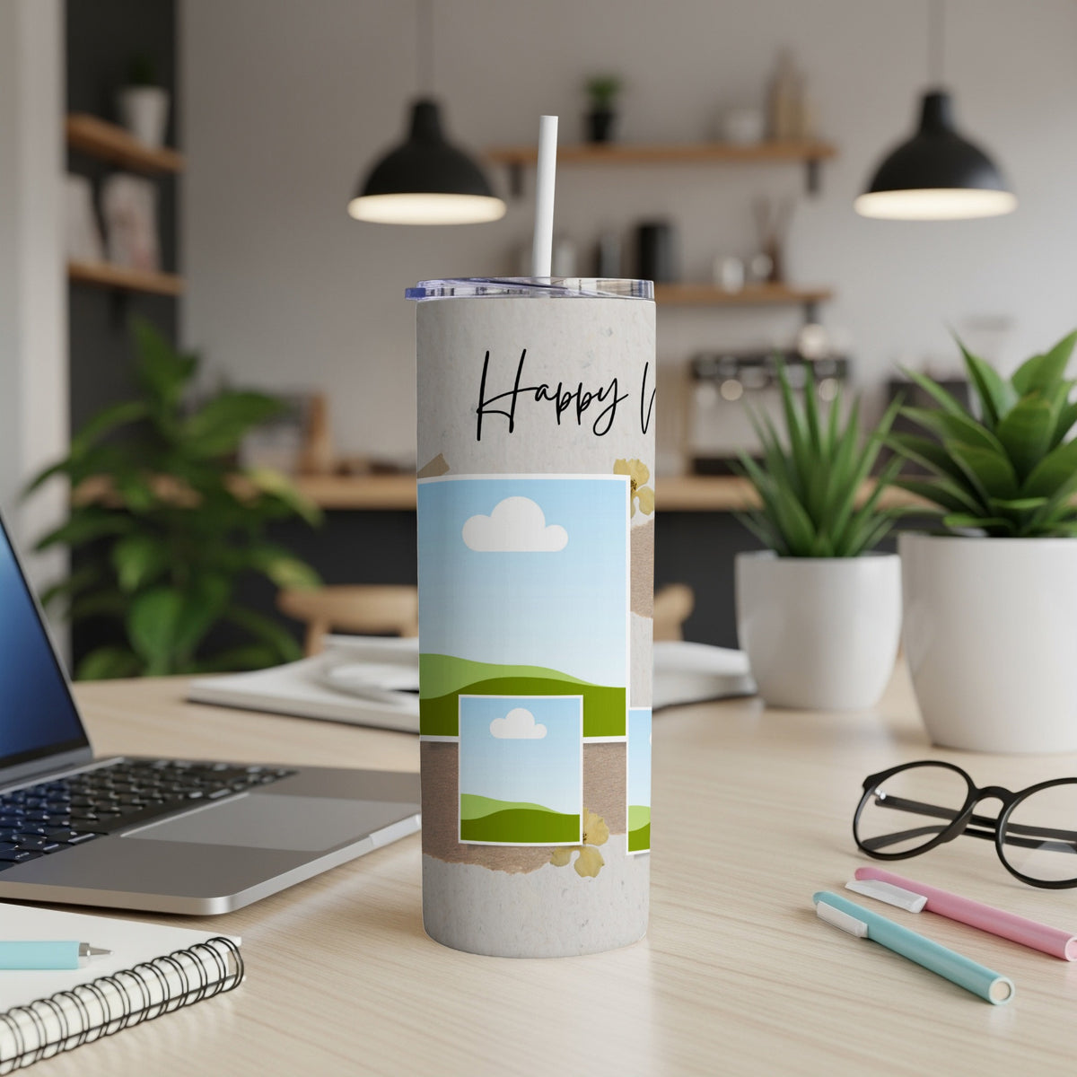 Tumbler with "Happy V" text and layered landscape photo collage on desk.