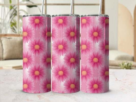 Three pink floral tumblers with straws on a marble surface.