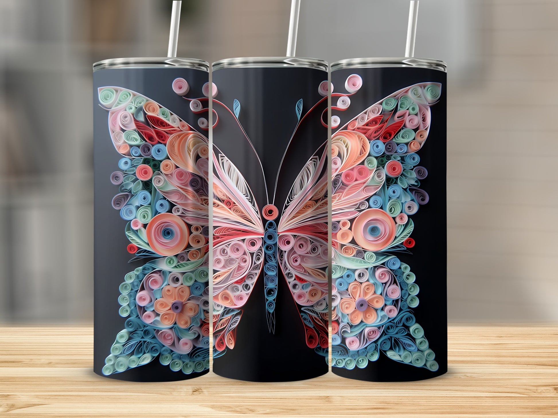 Three tumblers with intricate quilled butterfly designs in pastel colors on a black background.