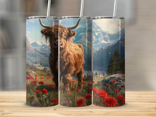 Highland cow in a field of red wildflowers with mountains in background.
