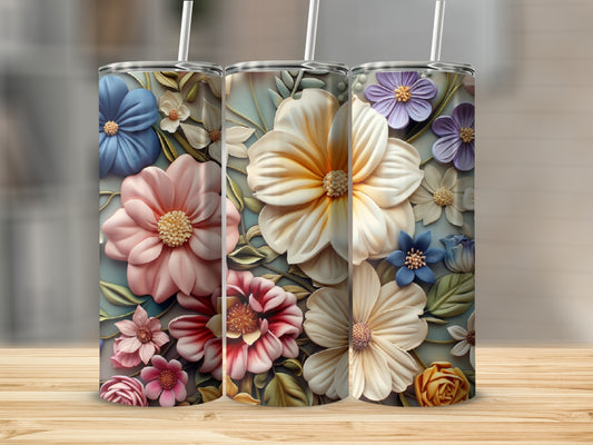 Three floral tumblers with raised flowers and straws on a wooden surface.