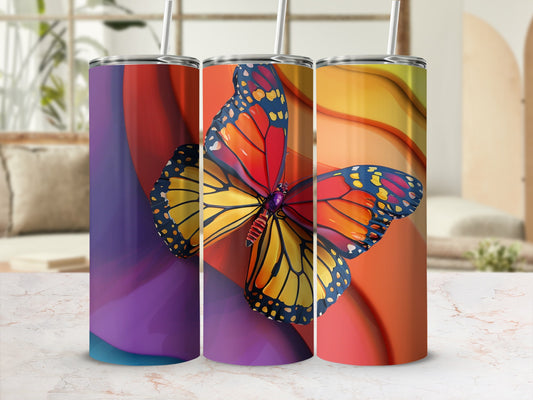 Three tumblers with vibrant butterfly designs in a studio setting.