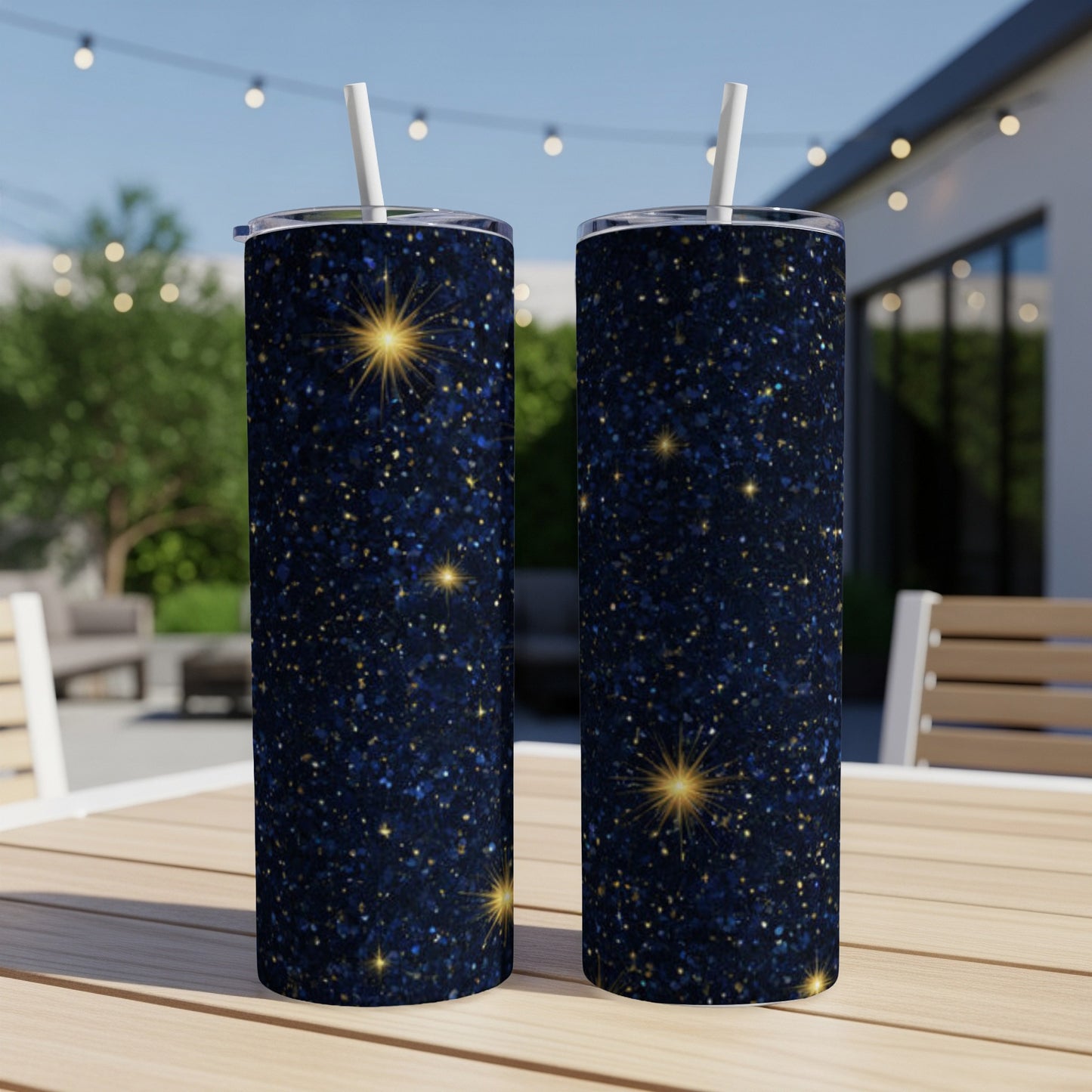Two tall, dark blue glitter tumblers with golden starbursts, standing on a table.