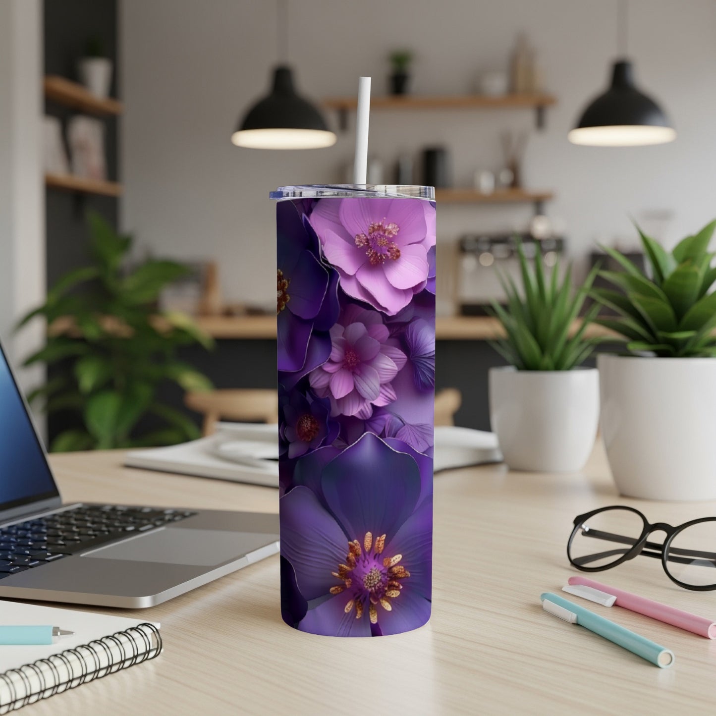 Purple floral tumbler with straw on a desk.