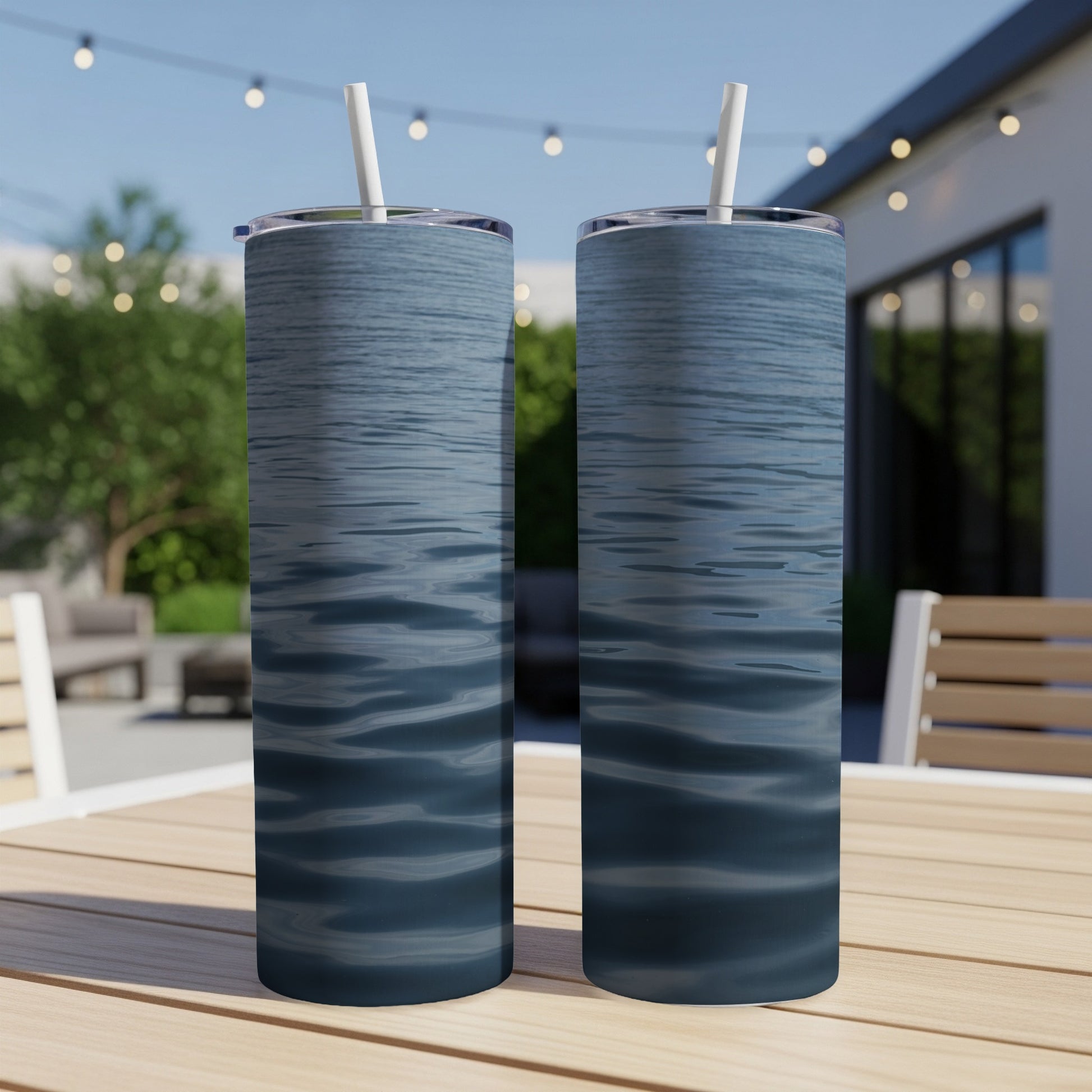 Two tall tumblers with a rippling water pattern sit on a table.
