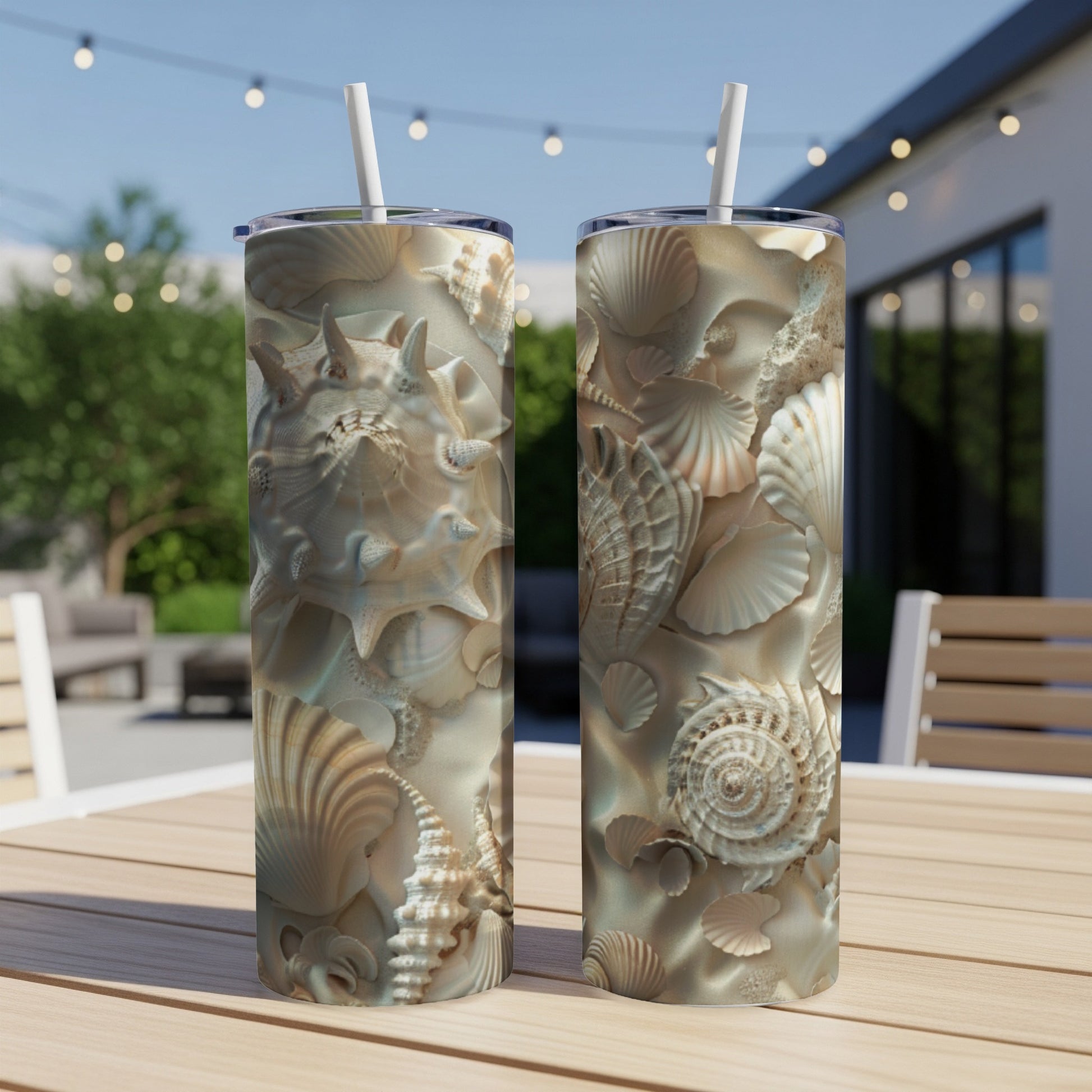 Two tall tumblers with detailed seashell designs on a sandy background.