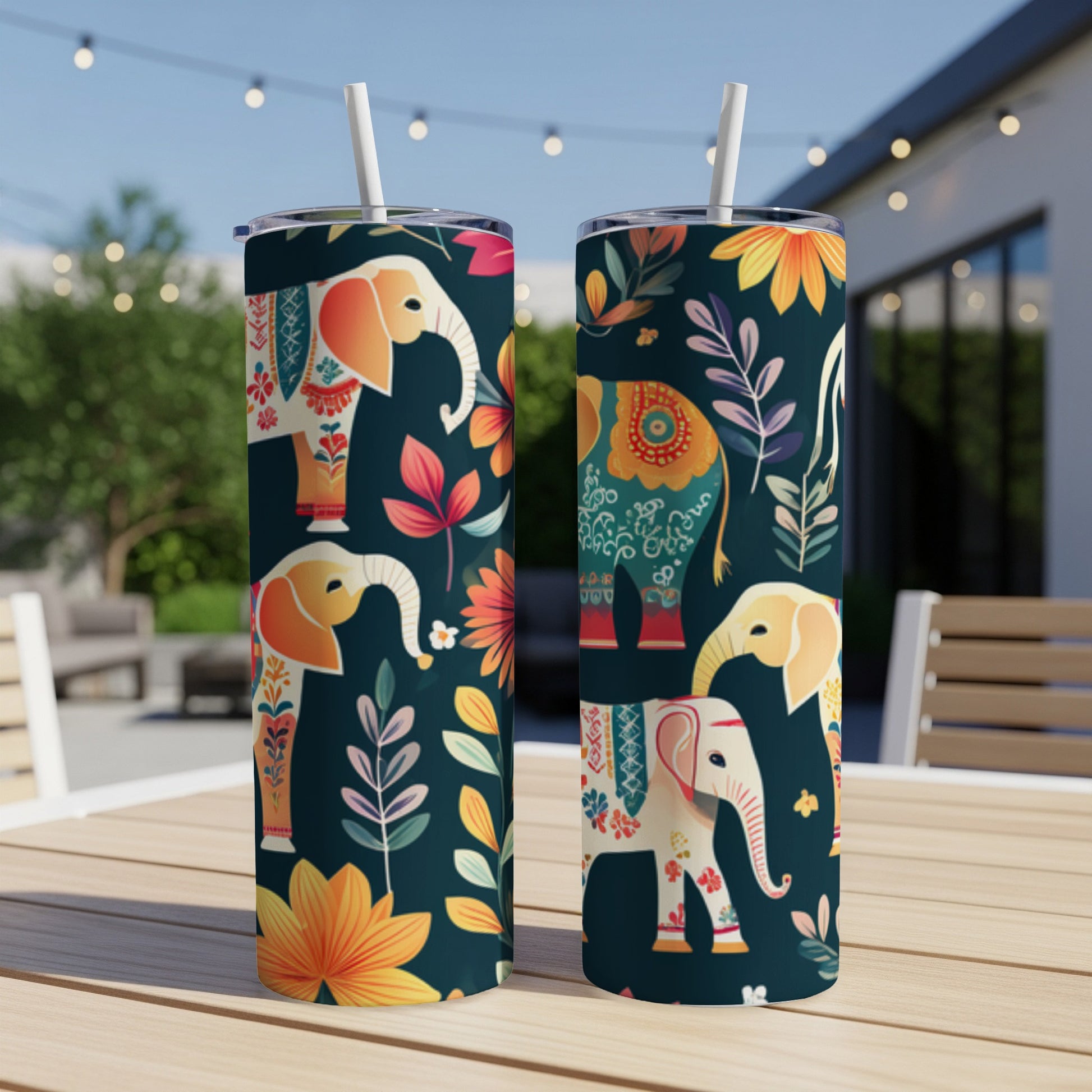 Two tumblers with colorful elephant and floral patterns on a patio table.